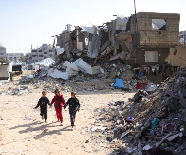 children hold hands amid the rubble