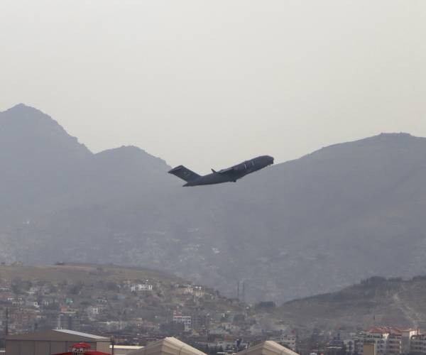 a plane takes off with mountains in the background