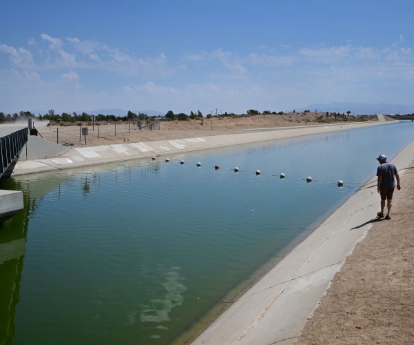 a man walks beside an aqueduct