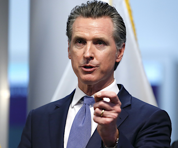 gavin newsom gestures during a news conference