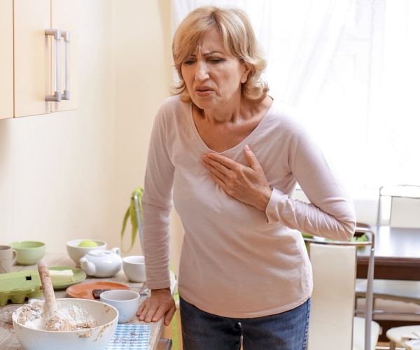 woman in kitchen having chest pain