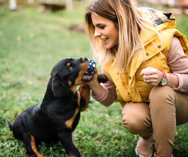 woman playing with a ball with a dog