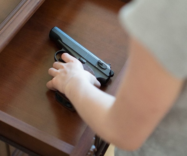 a young child's hand on gun