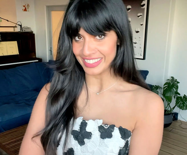 head and shoulders portrait of a smiling jameela jamil in a shoulder baring dress