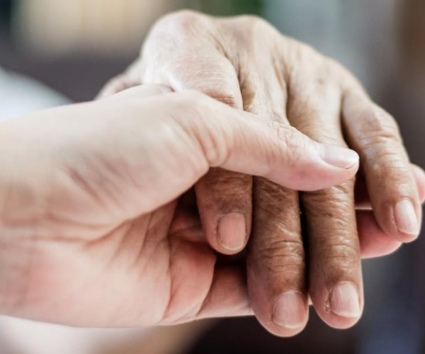 a younger hand holding an older person's hand