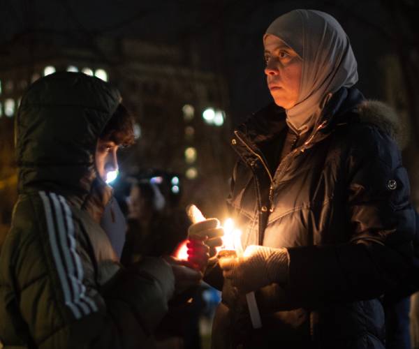 a boy and woman holding candles