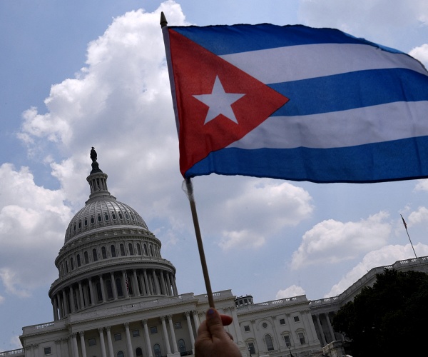 hand waves cuban flag in front of us capitol