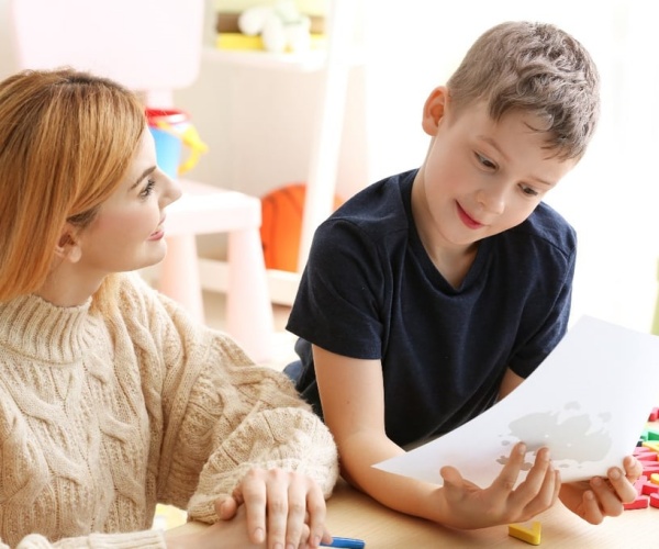 young boy working with a therapist while playing