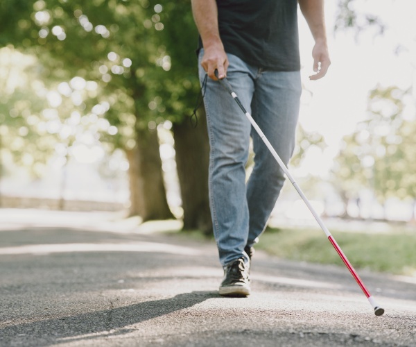 man walking in park with walking stick