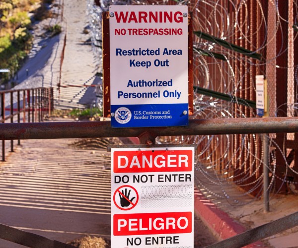 english and spanish warning signs at us mexcio border 