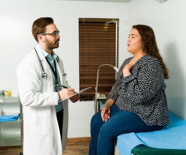 male doctor talking to female patient in exam room