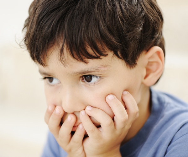 a boy looking sad, looking away