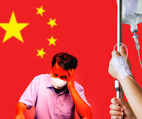 a man buries his head in his hand in front of a china flag