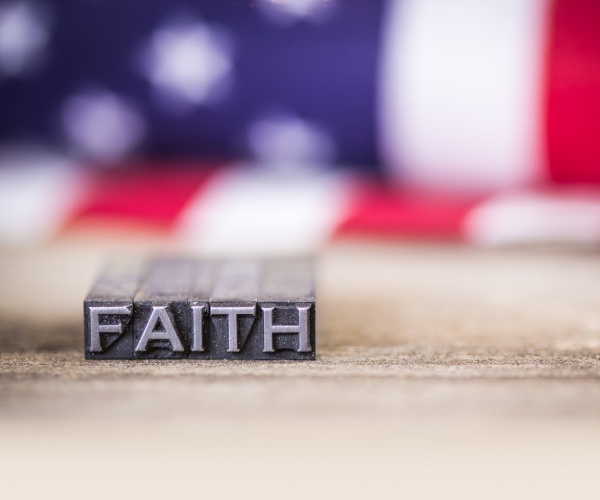 word faith  in vintage letterpress type on  wooden floor with us flag in the background