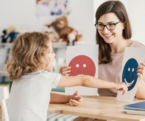 a therapist working with a young child at a desk