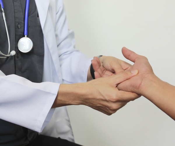 doctor holding trembling hand of Parkinson's patient