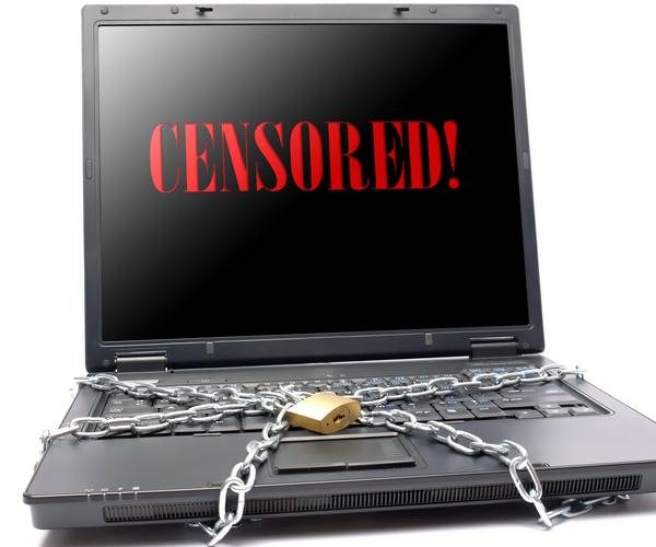 a laptop computer with censorship written on the the screen and chains and padlocks on the keyboard