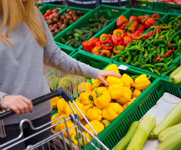 woman shopping in produce section of grocery store