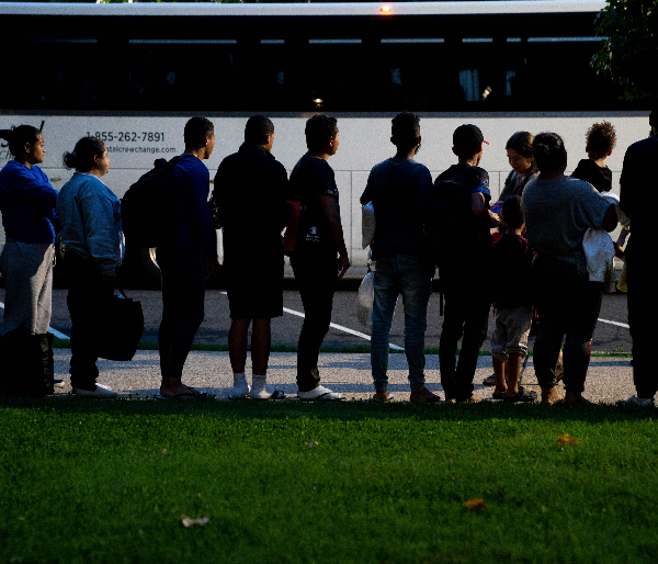 Migrants lined up near a bus