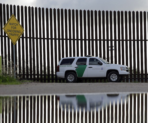 border patrol vehicle in front of a border wall