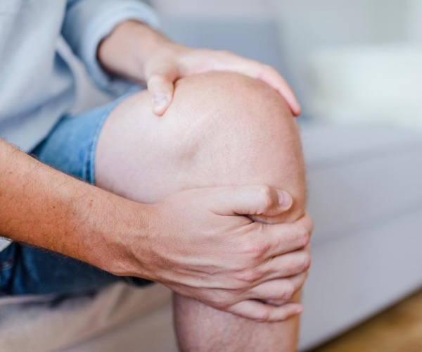 man holding knee in pain