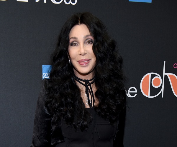 cher stands on red carpet