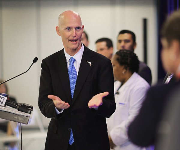 rick scott speaks at a business opening