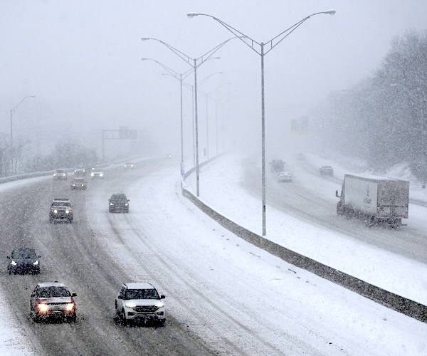 vehicles drive along a highway during a winter storm