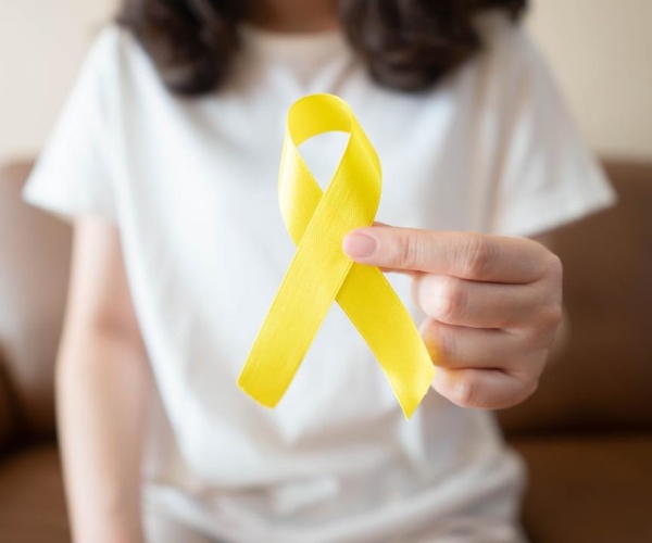 person holding a yellow ribbon for suicide prevention awareness