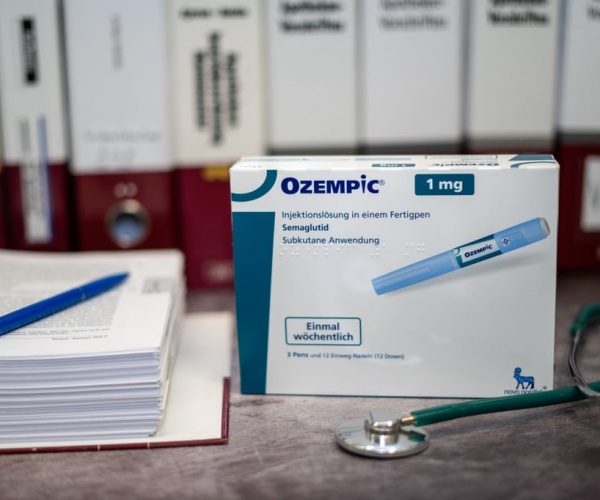 Box of Ozempic cartridges next to a printed research study