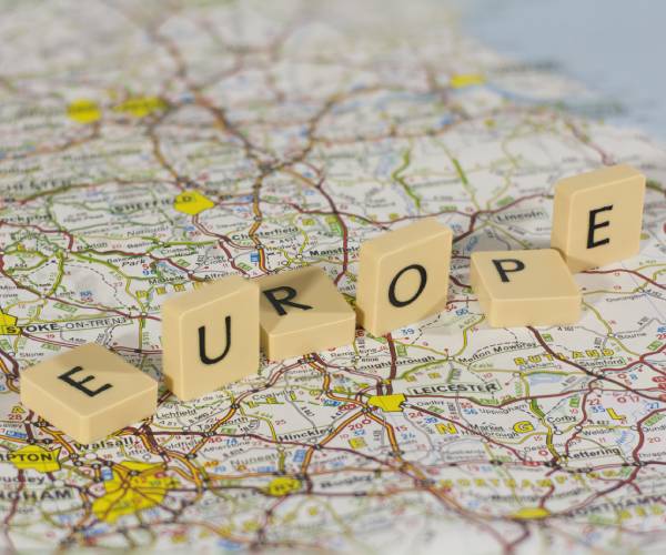 the word europe written with scrabble blocks and falling on a map