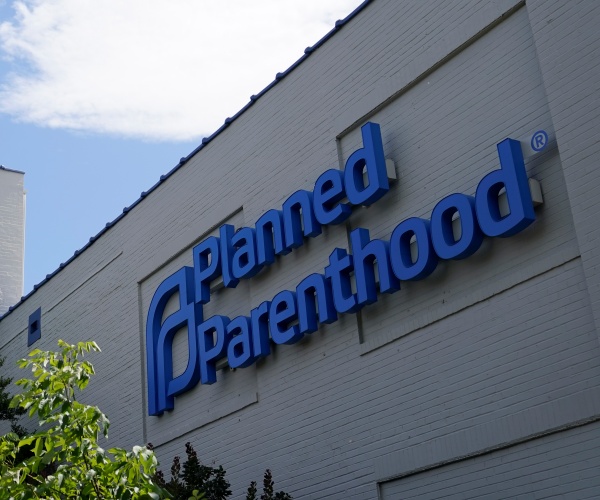 missouri and american flags fly outside planned parenthood