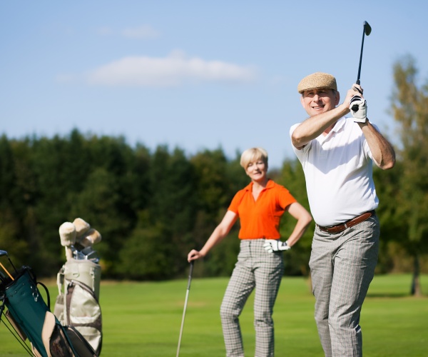 senior man and woman playing golf