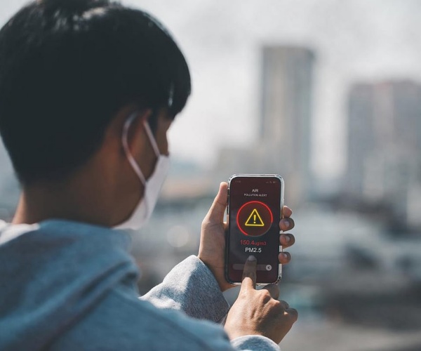 man assessing air pollution with smartphone