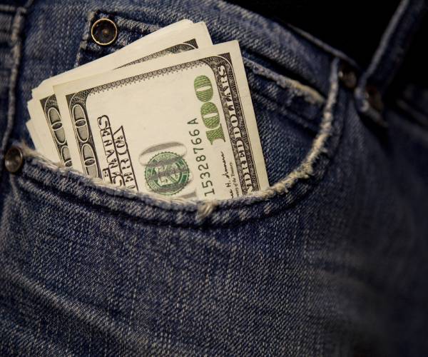 cash sticking out of a persons bluejeans pocket