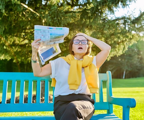 woman sitting outside on bench having menopausal hot flash