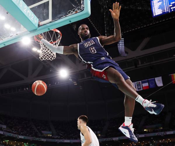 lebron james midair after dunking with the goal and the basketball in view