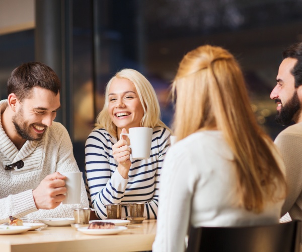 men and woman out at restaurant drinking coffee or tea