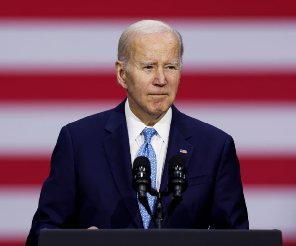 joe biden in suit with us flag in background