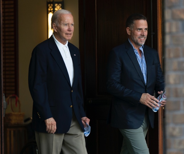 joe and hunter biden in dark suits looking to the right