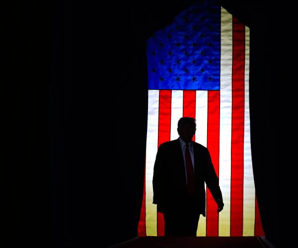 donald trump with an american flag behind him