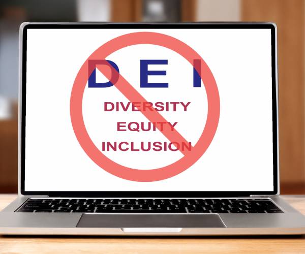 a laptop computer with the words diversity equity inclusion on the screen with a circle and slash through them