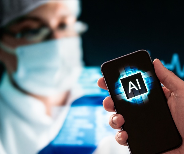 surgeon with mask holding a smartphone that says 'AI'