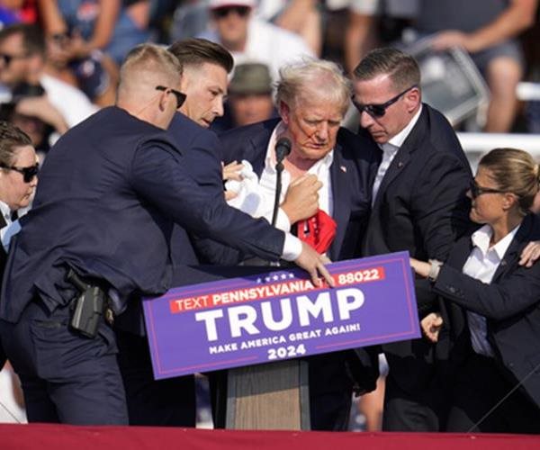 donald trump being helped off stage during a rally by secret service