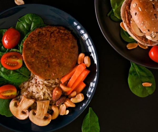 two plates with plant-based meat burgers