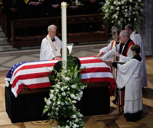 clergy surround jimmy carter's casket