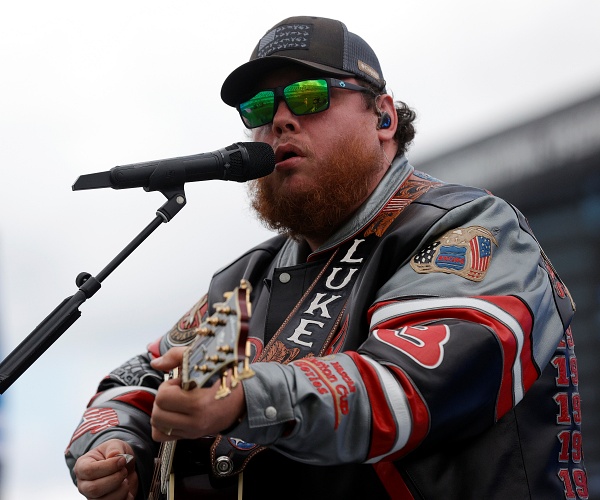 luke combs sings and plays guitar onstage