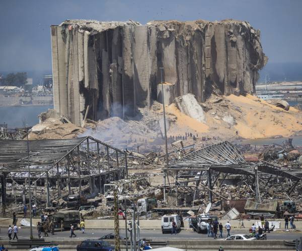 remnants of a building with people walking in the foreground