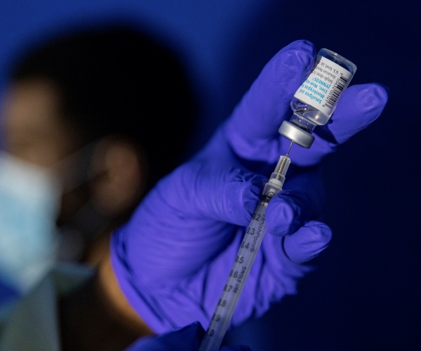 healthcare worker holding vial of Mpox vaccine and syringe