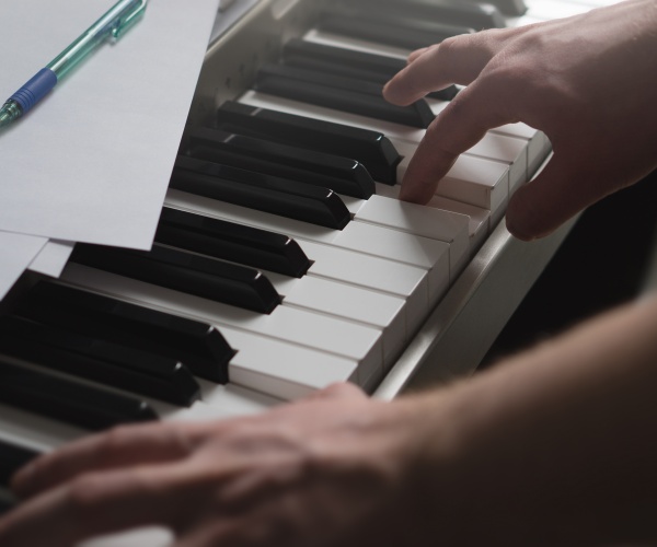 person learning to play piano